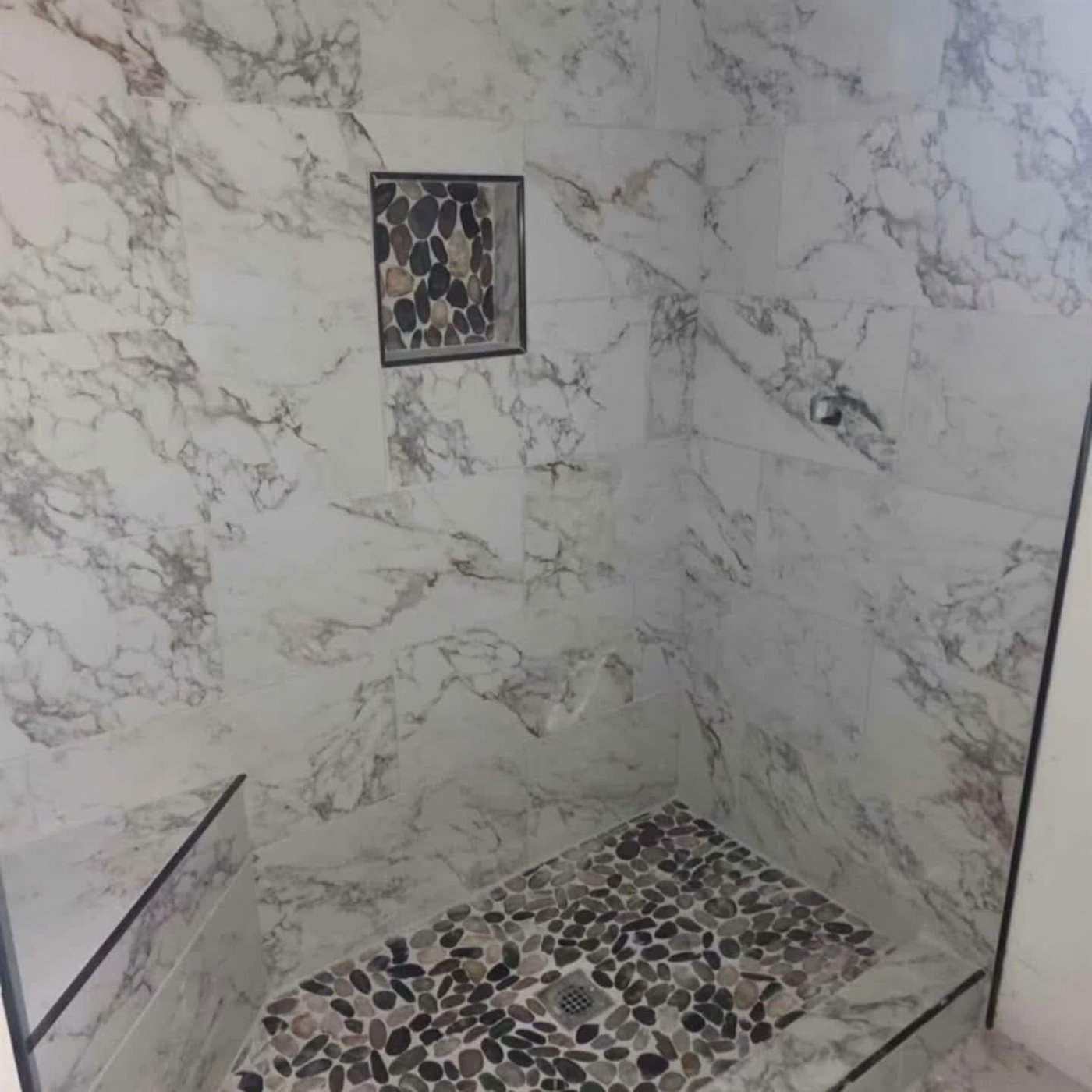 Marble shower, pebble floor & niche