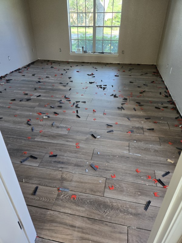 Wood-look plank tile being leveled